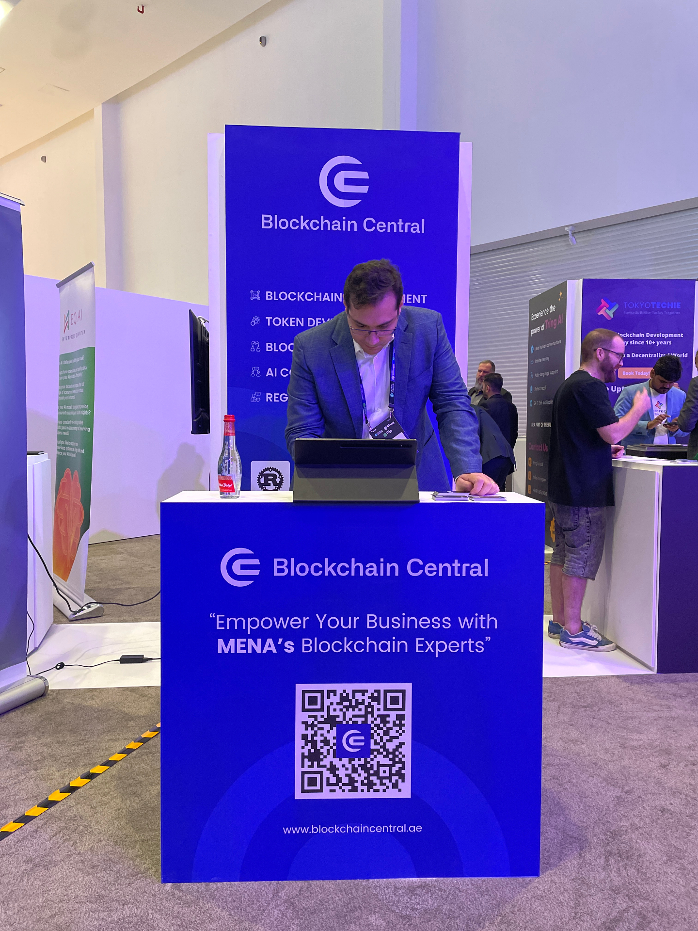 Team members welcoming attendees at the Blockchain Central booth